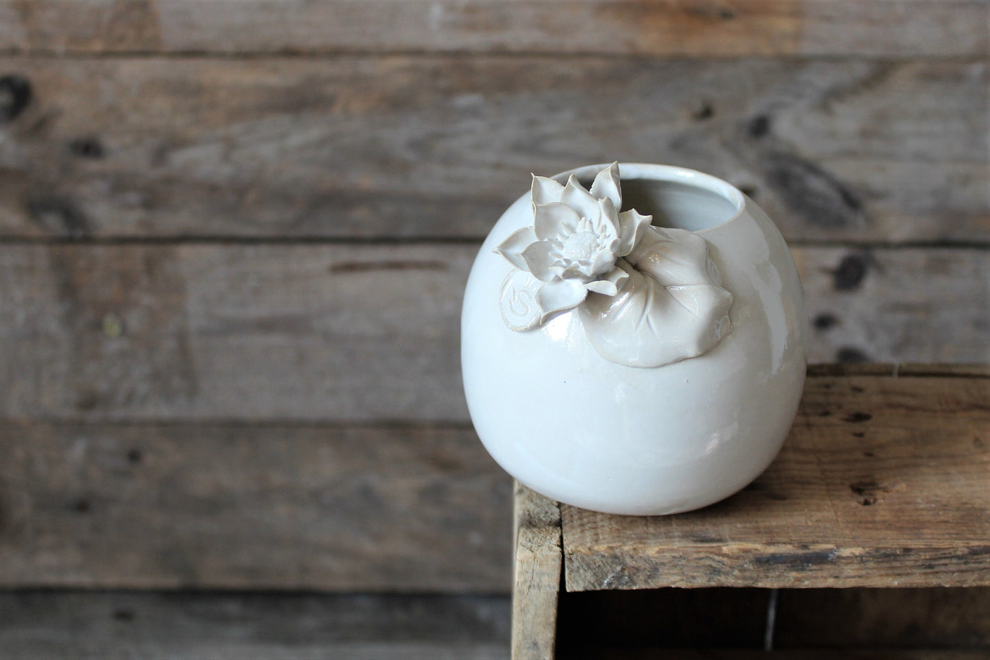 vaso sferico bianco in gres con fiore e foglia di ninfea