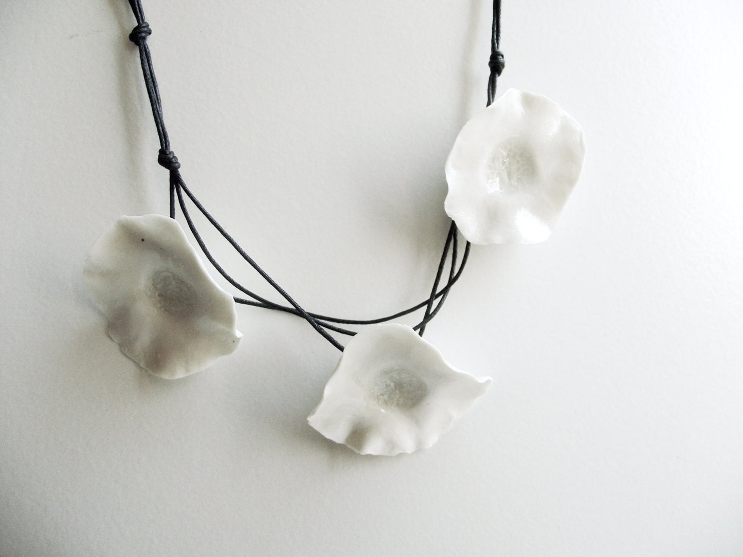 Collana di porcellana con tre fiori di porcellana bianca -