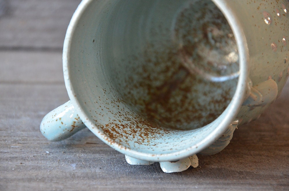Tazza in gres azzurra con fiore di viola del pensiero e puntini a rilievo