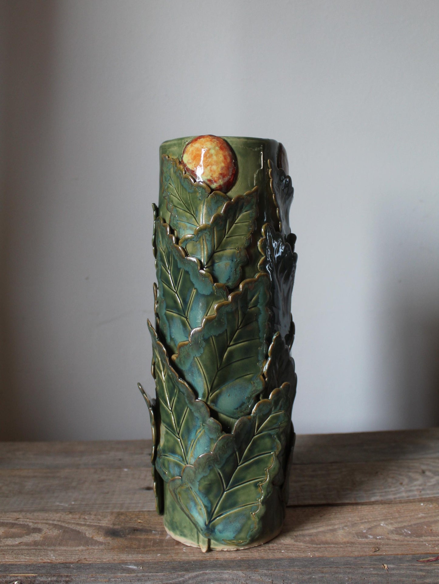 vaso cilindrico ispirato alle opere di Rousseau con foglie e arance