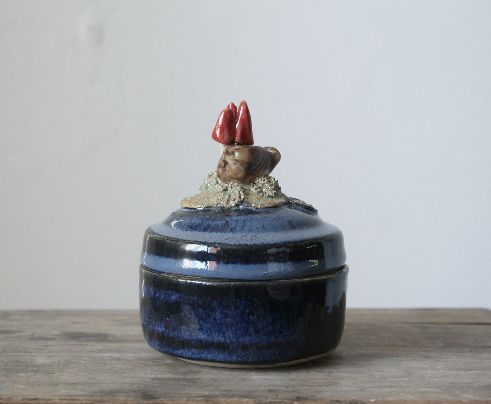 Scatola portagioie blu in gres con uccellino e funghetti rossi