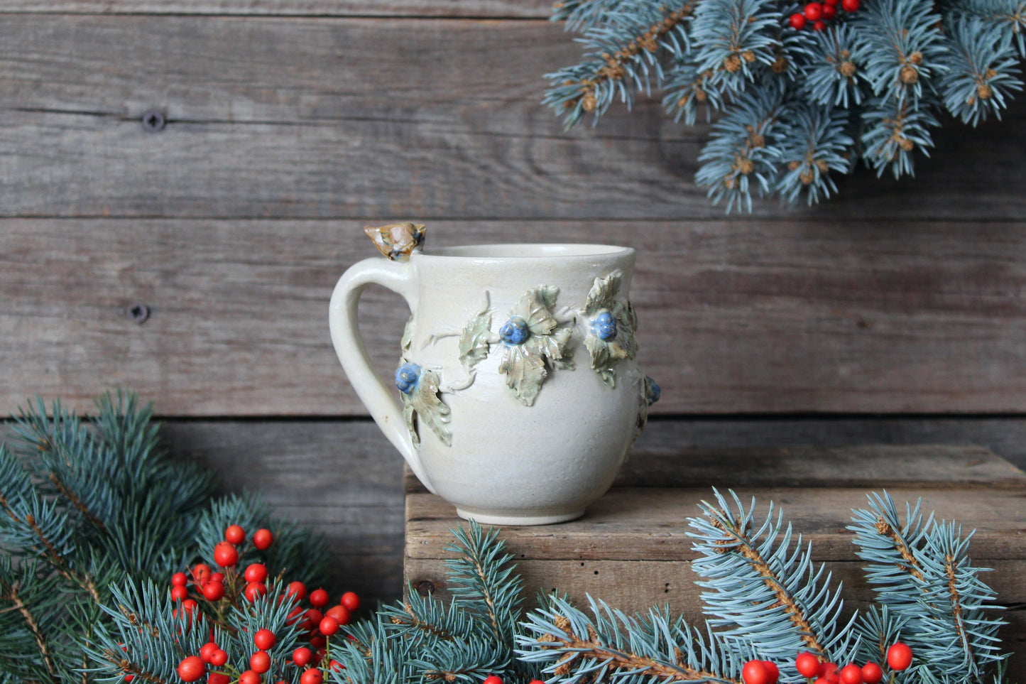 Tazza in gres color crema con uccellino sul manico e rami di more, fatta a mano al tornio