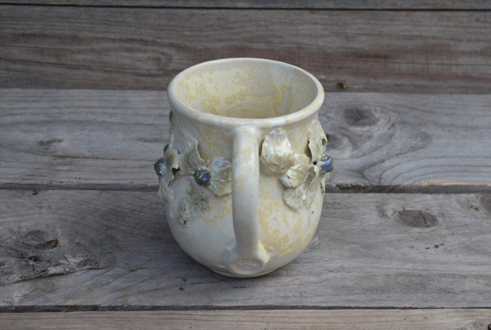 Tazza in gres color crema con uccellino sul manico e rami di more, fatta a mano al tornio
