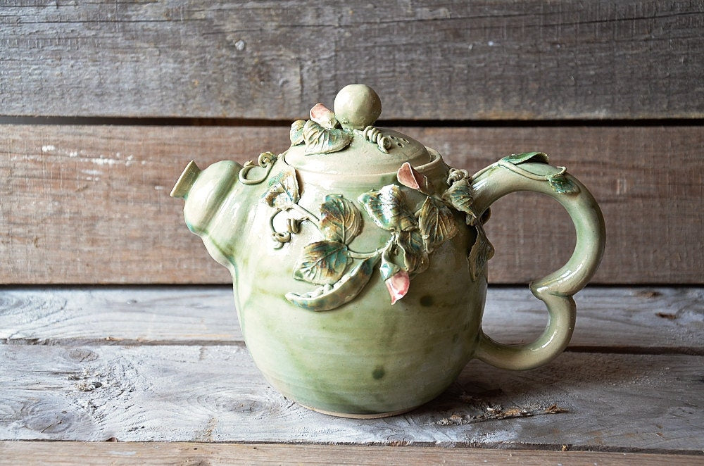 Teiera in gres azzurro con fiori, foglie e baccelli di pisello, fatta a mano al tornio