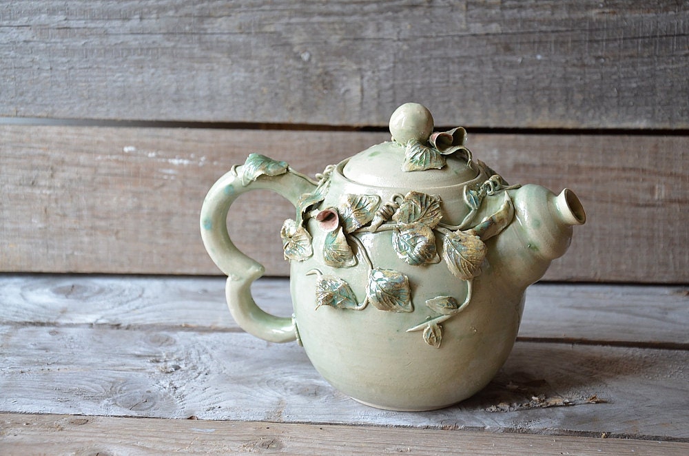 Teiera in gres azzurro con fiori, foglie e baccelli di pisello, fatta a mano al tornio