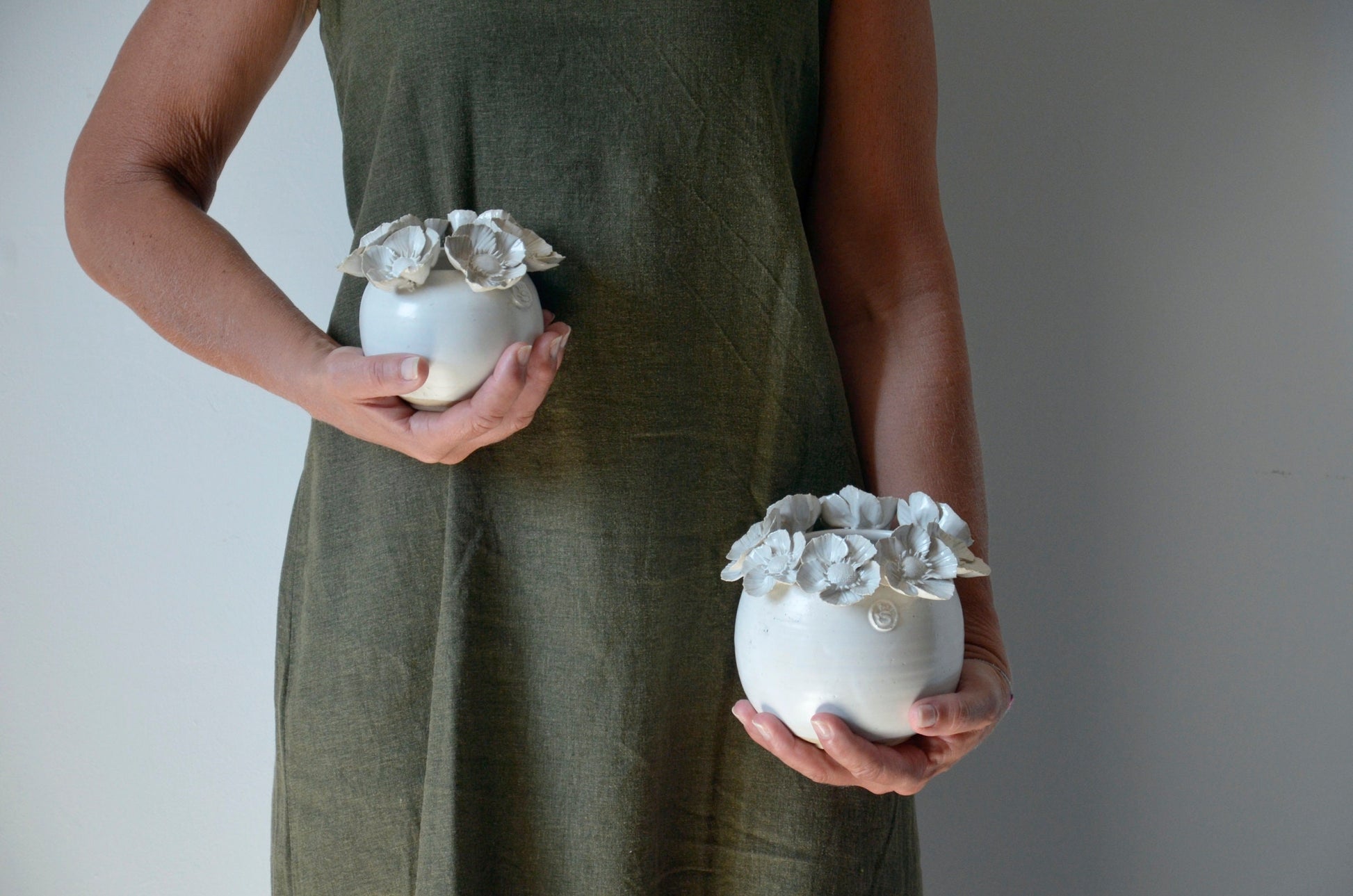 Vaso sferico bianco in gres con una corolla di fiori di dalia sulla sommità