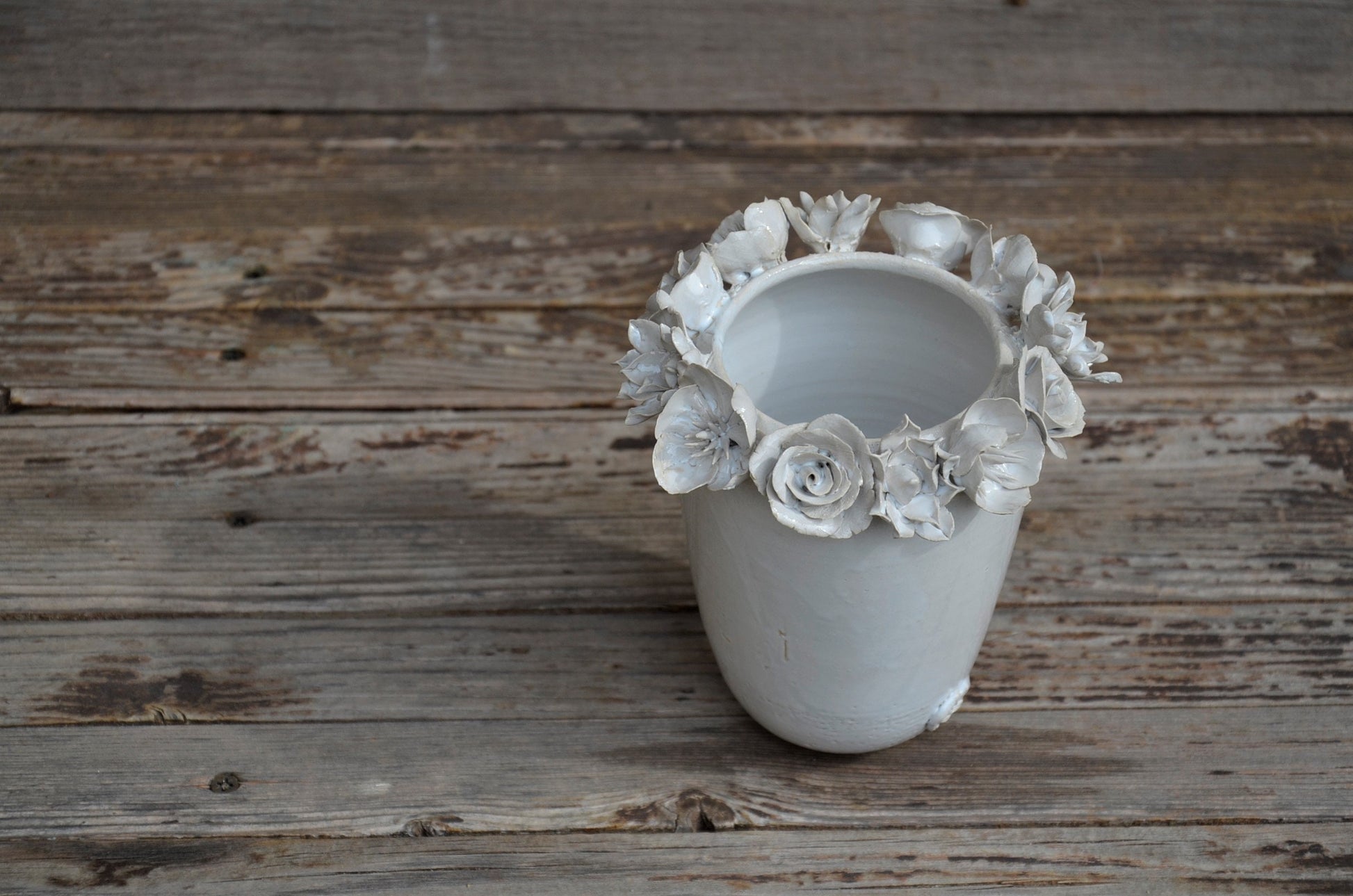 Vaso alto bianco in gres con una corolla di fiori misti sulla sommità