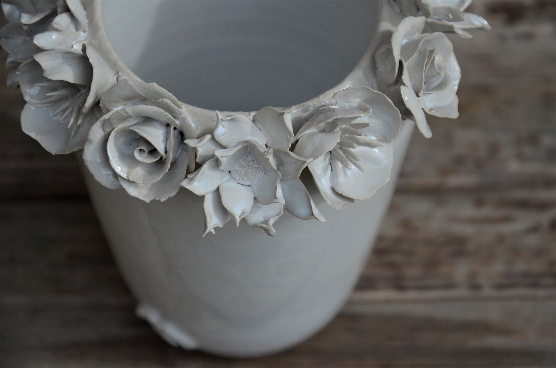 Vaso alto bianco in gres con una corolla di fiori misti sulla sommità