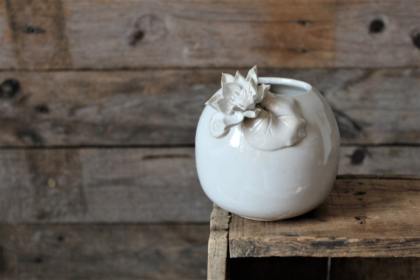 vaso sferico bianco in gres con fiore e foglia di ninfea